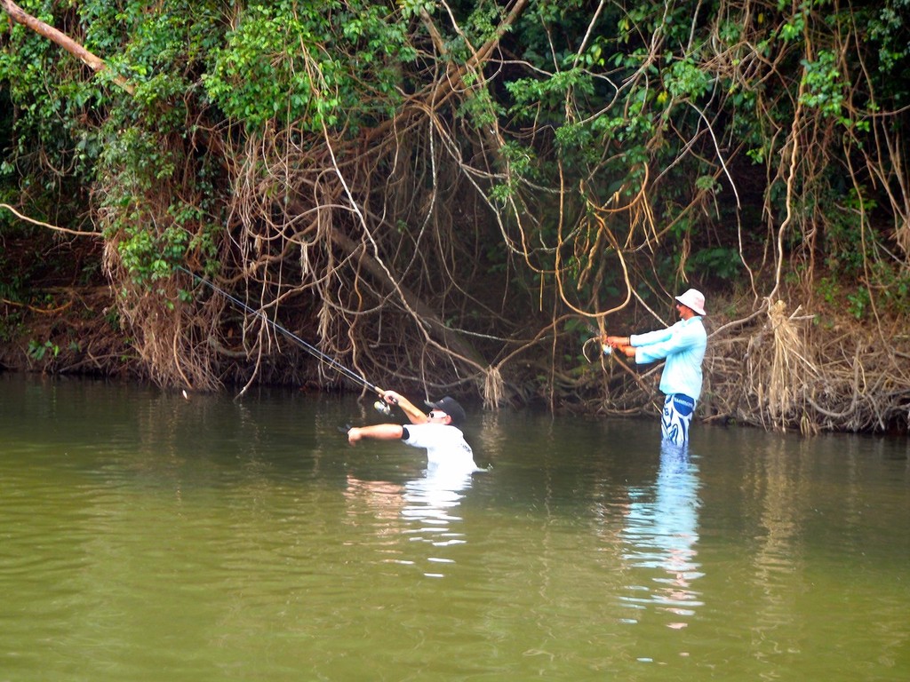 The author (rear) and Deion Capra work poppers for marauding sooty grunter in a freshwater stream.  Note the deep channel Deion is falling into.  Such drop-offs will often hold fish, especially if there is rock or fallen timber in the equation.   © Lee Brake